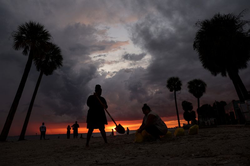 Moradores de Tampa, no Estado norte-americano da Flórida, enchem sacos de areia na praia para esperar o impacto do furacão Ian. REUTERS/Shannon Stapleton