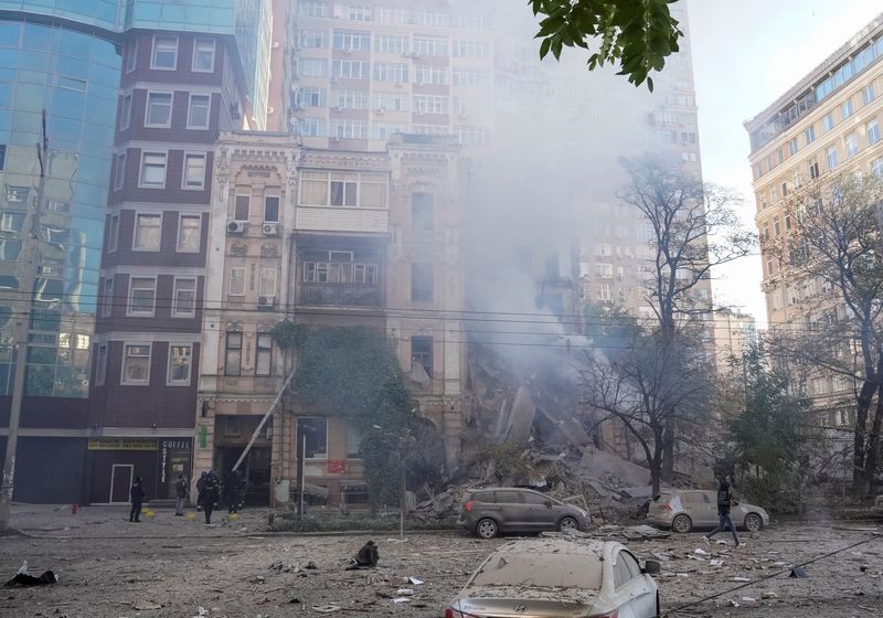 Bombeiros ajudam mulher a sair de conjunto de prédios residenciais atingido por um ataque de drone da Rússia em Kiev